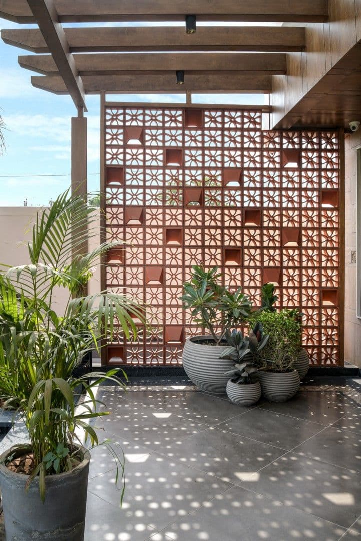 Terracotta jaali and stone surfaces in a curated APOSH outdoor space